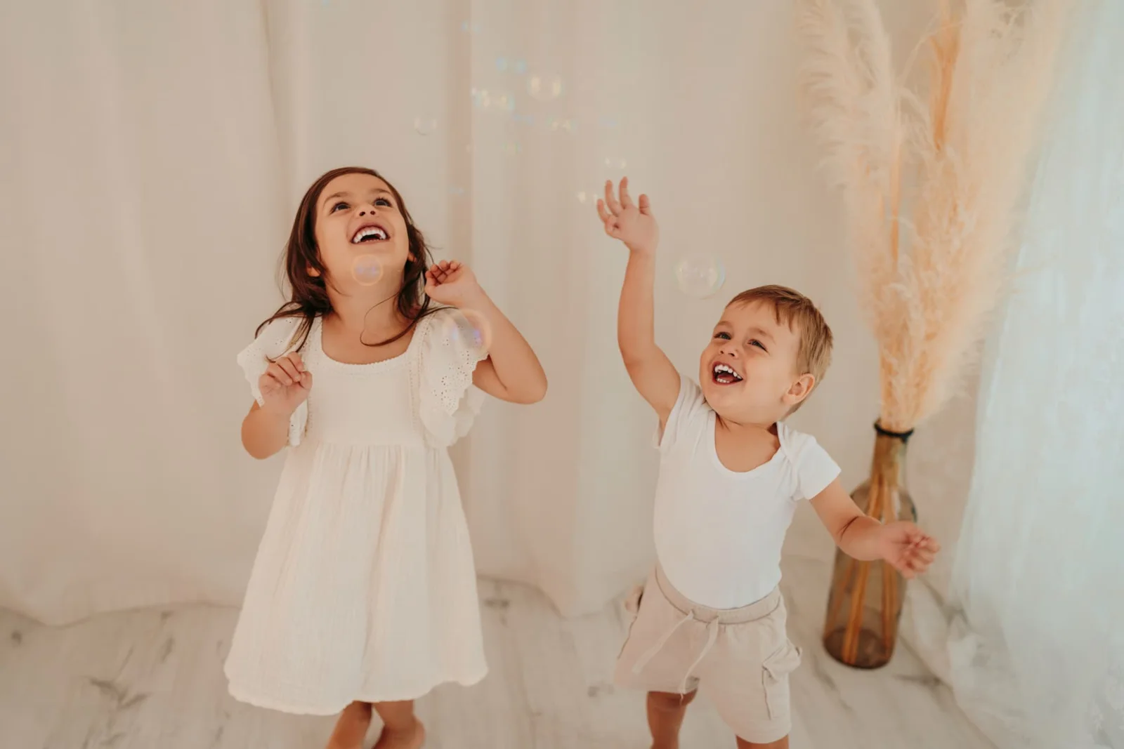 Estis Kinder spielen lachend mit Seifenblasen